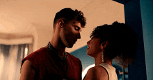 a man and a woman are looking at each other in a room