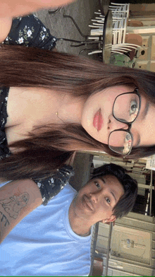 a man and a woman are posing for a picture and the woman has a tattoo on her arm that says " i love you "