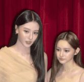 two women with long hair are standing next to each other