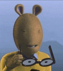 a cartoon character wearing a mask and glasses is holding a cell phone .