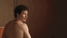 a shirtless man is standing in front of a mirror