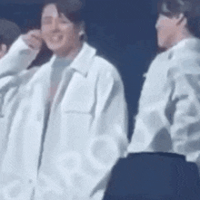 a group of men are standing next to each other on a stage and talking to each other .