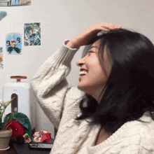 a woman in a white sweater is smiling and looking up
