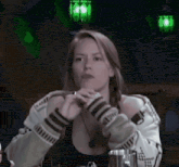 a woman is sitting at a table in front of a green light .