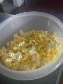 a clear plastic bowl filled with yellow popcorn