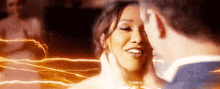 a man and a woman are dancing together in a dark room and the woman is smiling .