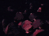 a person playing a set of drums with a red light behind it