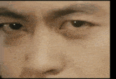 a close up of a man 's face with his eyes looking at the camera .