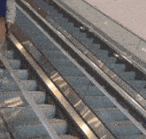 a man is walking down an escalator with a reflection of him