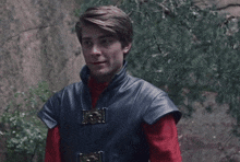 a man wearing a black leather vest and a red shirt