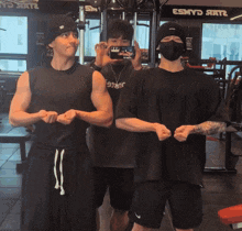 a man wearing a mask is taking a picture of two other men in front of a sign that says esmy star