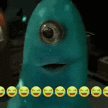 a blue monster with one eye is surrounded by smiley faces and laughing emojis .