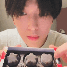 a close up of a person holding a box of chocolates in their hands
