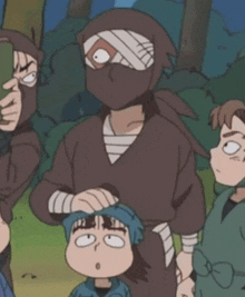 a group of ninjas are standing next to each other and one of them has a bandage on his head .