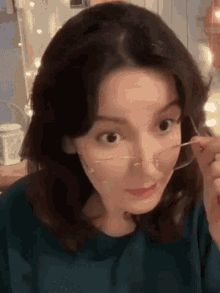 a close up of a woman wearing glasses making a funny face .