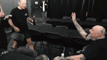 a man with a tattoo on his arm is sitting at a table with other men