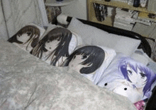 a bed with a lot of pillows and a blanket with anime characters on them .