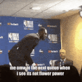 a man stands in front of a wall that says nba finals on it