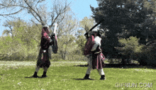 a gif from gifrun.com shows two men fighting in a park