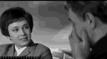 a black and white photo of a man and a woman talking to each other