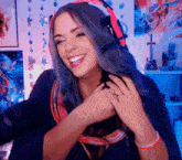 a woman with blue hair wearing headphones and a ring on her finger