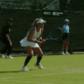a woman is holding a tennis racquet in front of a challenger tour sign