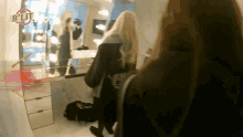 a woman standing in front of a mirror with the word blit on the bottom right