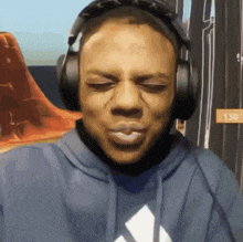 a man wearing headphones and a blue hoodie with the number 130 on it