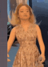 a woman in a dress is holding a microphone and making a face .