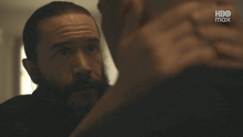 a man with a beard looks at another man with the words everything happens for a reason
