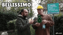 two men are standing in front of a sign that says " bellissimo "