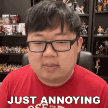 a man wearing glasses and a red shirt that says just annoying on it