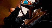 a man in a fur coat is driving a car and looking out the window