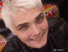 a man with white hair is smiling in front of a sign that says ' me '