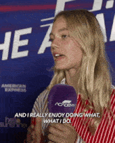 a woman talking into a microphone with the words " and i really enjoy doing what what i do " behind her