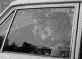 a black and white photo of a man and a woman in a car