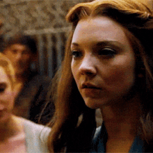 a close up of a woman 's face with a man in the background .
