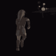 a person is walking in the dark with a balloon in the background .