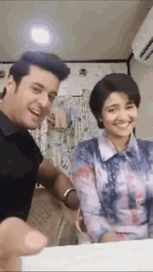 a man and a woman are sitting at a table laughing and smiling .