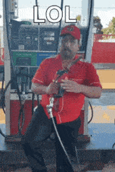 a man in a red shirt is sitting in front of a gas pump with the word lol written on it
