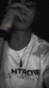 a man wearing a white shirt that says htaow