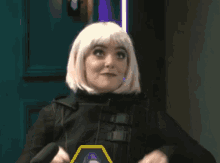 a woman wearing a wig and a black jacket is standing in front of a green door