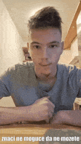 a young man sitting at a table with a caption that says " znaci ne moguce da ne mozete "