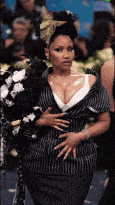 a woman wearing a black and white striped suit is holding a bouquet of flowers
