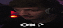 a man wearing headphones has the word ok written on his face