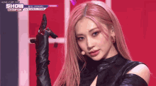 a woman with pink hair is wearing black gloves
