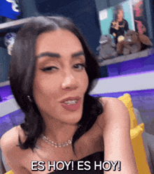 a woman says es hoy es hoy while sitting in a chair