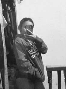 a girl is taking a selfie with her phone while wearing a hoodie with the word superdry on it