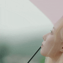 a woman with blonde hair is looking out of a window