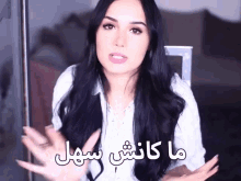 a woman with long black hair is talking in a video with arabic writing
